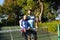 Portrait of happy caucasian couple playing tennis embracing by the net on sunny outdoor tennis court