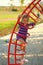 Portrait of happy caucasian four year old smiling girl climbing the ladder on the sunlit summer playground