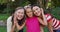 Portrait of happy caucasian grandmother, granddaughter and mother embracing in garden and smiling