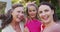 Portrait of happy caucasian grandmother, granddaughter and mother embracing in garden and smiling