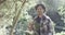 Portrait of happy caucasian man holding plant in sunny garden with copy space, slow motion