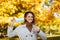 Portrait of happy caucasian millennial redhead female in raincoat taking off protective mask, show thumb up