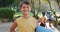 Portrait of happy caucasian schoolboy holding yoga mat after yoga lesson outdoors