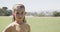 Portrait of happy caucasian schoolgirl at stadium of elementary school on sunny day in slow motion