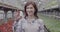 Portrait of happy Caucasian woman advertising bottle of pesticides in greenhouse. Positive beautiful Caucasian biologist