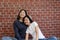 Portrait of a happy and charming Asian LGBTQ couple sitting at their new home and smiling at the camera