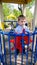 Portrait of happy cheerful toddler boy pretending to be a captain of ship on the children playground at park and