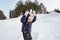 Portrait of a happy child boy throws snow, snowflakes in the air in cold winter against the background of snowdrifts