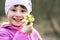 Portrait of happy child girl holding bunch of early spring snowdrops flowers outdoors