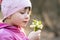 Portrait of happy child girl holding bunch of early spring snowdrops flowers outdoors