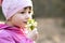 Portrait of happy child girl holding bunch of early spring snowdrops flowers outdoors