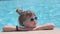 Portrait of happy child girl relaxing on swimming pool side on sunny summer day during tropical holidays