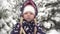 Portrait of a happy child outdoors in winter. Girl child smiles on a winter day on a background of snow