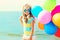 Portrait happy child on summer beach with colorful balloons