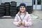 Portrait of a happy child with wrenches against the background of a garage and wheel tires and vehicle service.  Auto repair