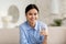 Portrait of happy chinese lady holding glass of water