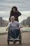 Portrait of happy couple - caring woman with disabled man in wheelchair