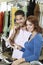 Portrait of a happy couple with man with telephone receiver and woman with paper in store