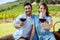 Portrait of happy couple offering wineglasses