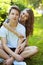 Portrait happy couple teenagers sitting on the grass in summer