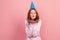 Portrait of happy curly haired teenage girl in hoodie with party hat sending air kiss at camera, holiday greeting, flirt