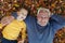 Portrait of happy cute grandfather and grandson with autumn leaves