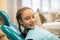 Portrait of happy cute patient girl in the dental room.