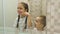 Portrait of happy cute siblings brushing teeth near mirror in bathroom at home, having fun and smiling. Children daily