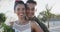 Portrait of happy diverse bride and groom smiling at sunny beach wedding, in slow motion