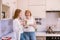 Portrait of a happy elderly mother and daughter in modern light kitchen interior