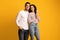 Portrait of happy embracing middle eastern couple posing over yellow background