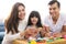 Portrait of happy family daughter girl is learning to use colorful play dough blocks toy together with parent.