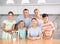 Portrait of happy family - father and mother with four children at table at home