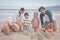 Portrait of happy family making sand castle