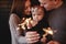 Portrait of happy family, mom, dad and baby girl with sparklers and light. family in anticipation of Christmas. selective photo