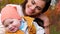 Portrait of happy family, mom near baby with drooling close-up on background of yellow trees in autumn city park