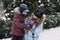 Portrait of happy family mother, son and cat in snowy winter park. Outdoors Portrait of mom and kid boy with cat hugging