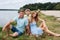 Portrait of a happy family in nature, on the banks of a picturesque river