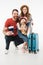 Portrait of happy family of tourists with suitcase