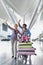 Portrait of happy family waving in arrival area at airport