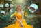 Portrait of happy fantasy woman blonde forest fairy. Fashion model in a bright yellow dress with butterfly wings sits