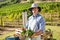 Portrait of happy farmer holding a crate of fresh vegetables