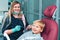 Portrait of happy female dentist in mask sitting, holding dentist tools, smiling and examining young boy in dental chair, healthy