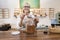 Portrait of a happy female employee pouring spice with scoop in jar