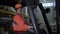 Portrait of happy female forklift truck driver looks at camera and smiles in warehouse