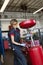 Portrait of a happy female mechanic working on welding equipment in garage