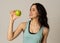 Portrait of happy fitness young latin woman with apple after workout training