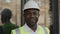 Portrait of happy foreman in helmet posing at building site