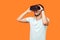 Portrait of happy gamer, brunette man playing virtual reality game. studio shot isolated on orange background