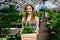 Portrait of happy gardener walking in hothouse with box of plants smiling